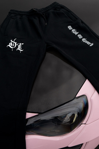 Black pants with white text and logo on a pink car