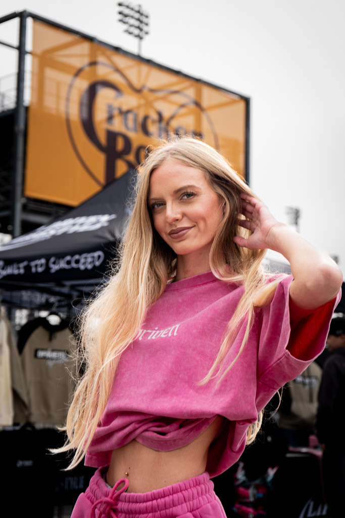 Woman in pink outfit posing in front of a Cracker Barrel sign