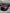 Purple car parked inside of a wrap shop with a branded flag banner behind it and LED hexagonal lights