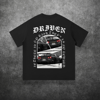 Black t-shirt with car graphic and 'Driven' text on a textured gray background
