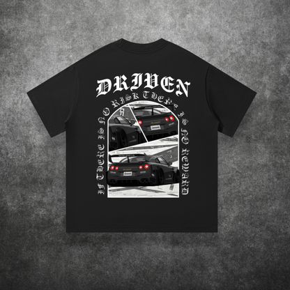 Black t-shirt with car graphic and 'Driven' text on a textured gray background