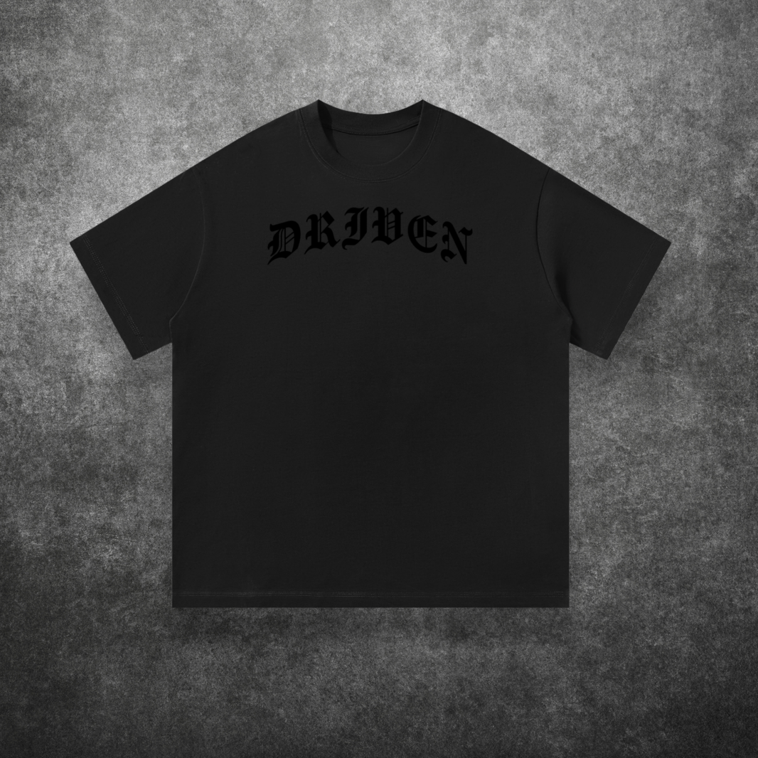 Black t-shirt with 'DRIVEN' text on a textured gray background