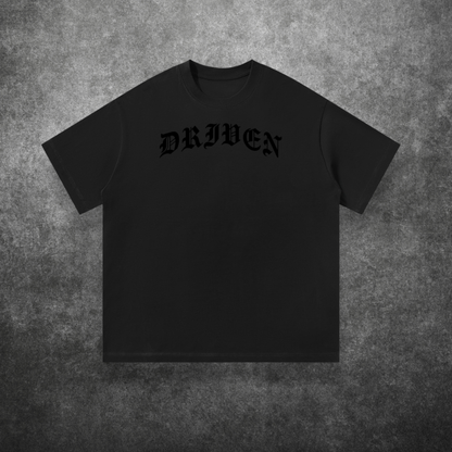 Black t-shirt with 'DRIVEN' text on a textured gray background