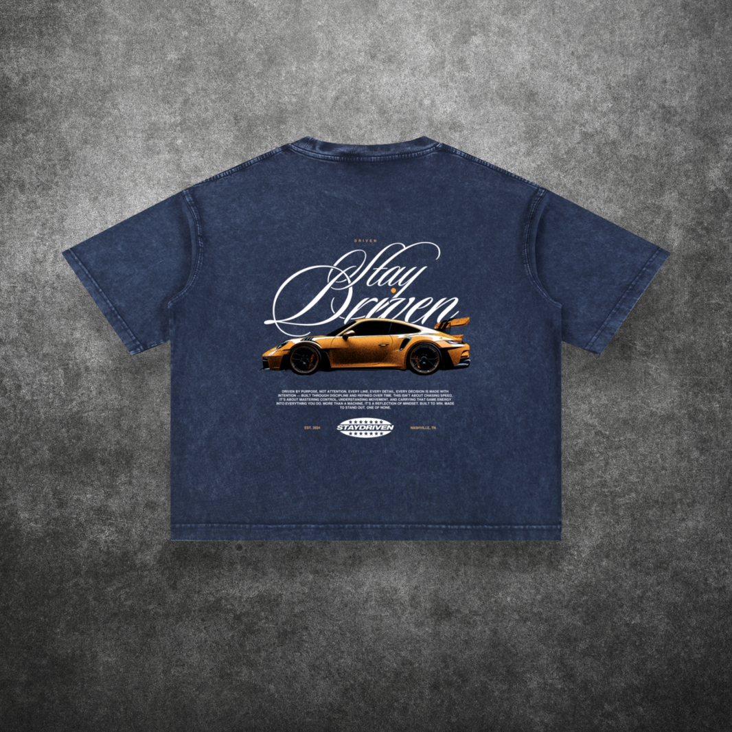Blue t-shirt with car graphic and text on a textured gray background