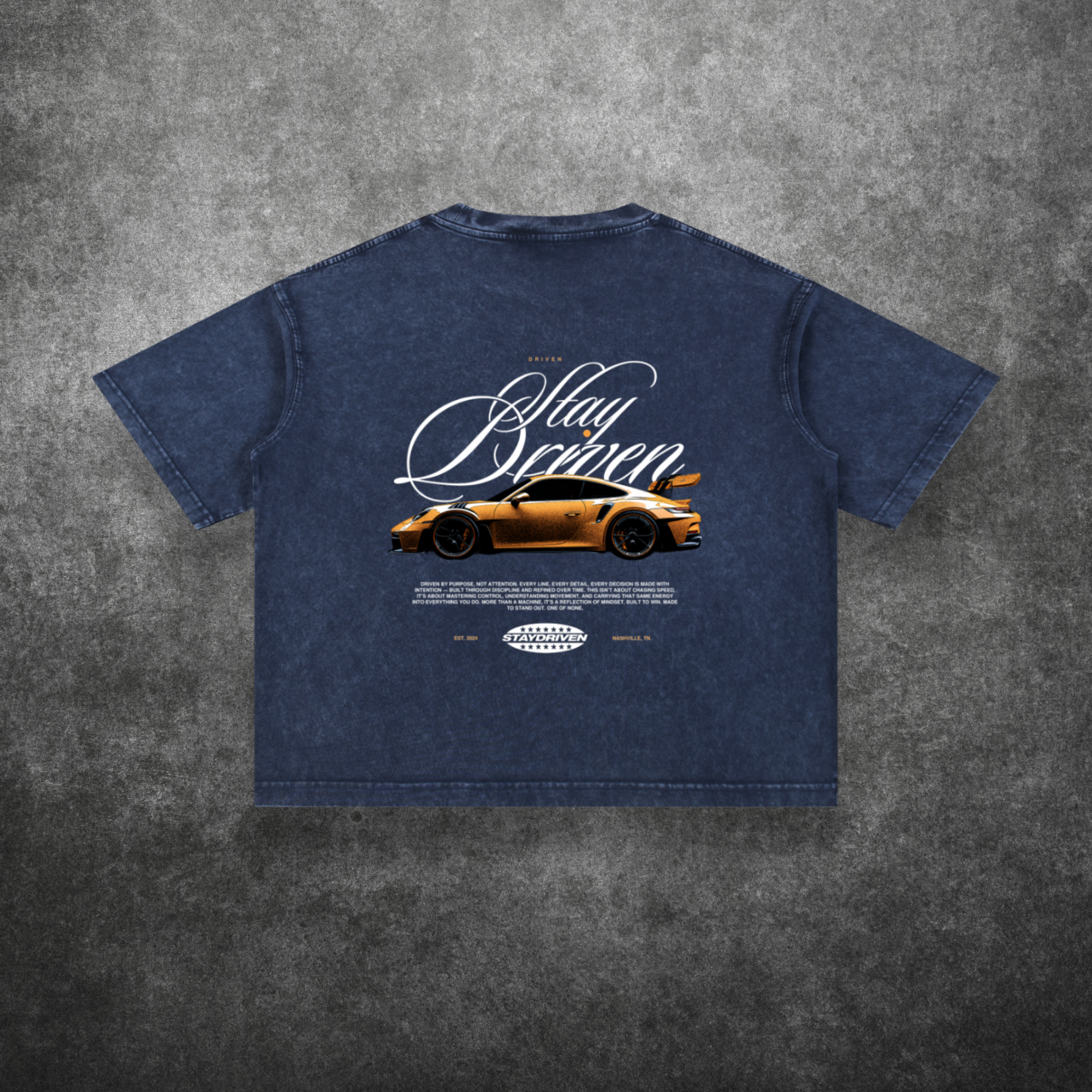 Blue t-shirt with car graphic and text on a textured gray background