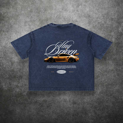 Blue t-shirt with car graphic and text on a textured gray background