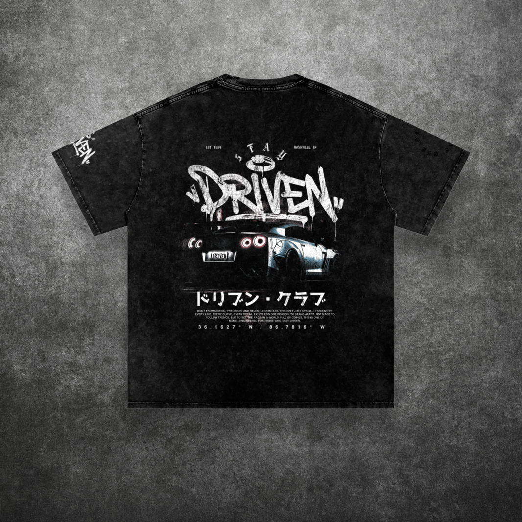 Black t-shirt with graphic design and text on a textured gray background