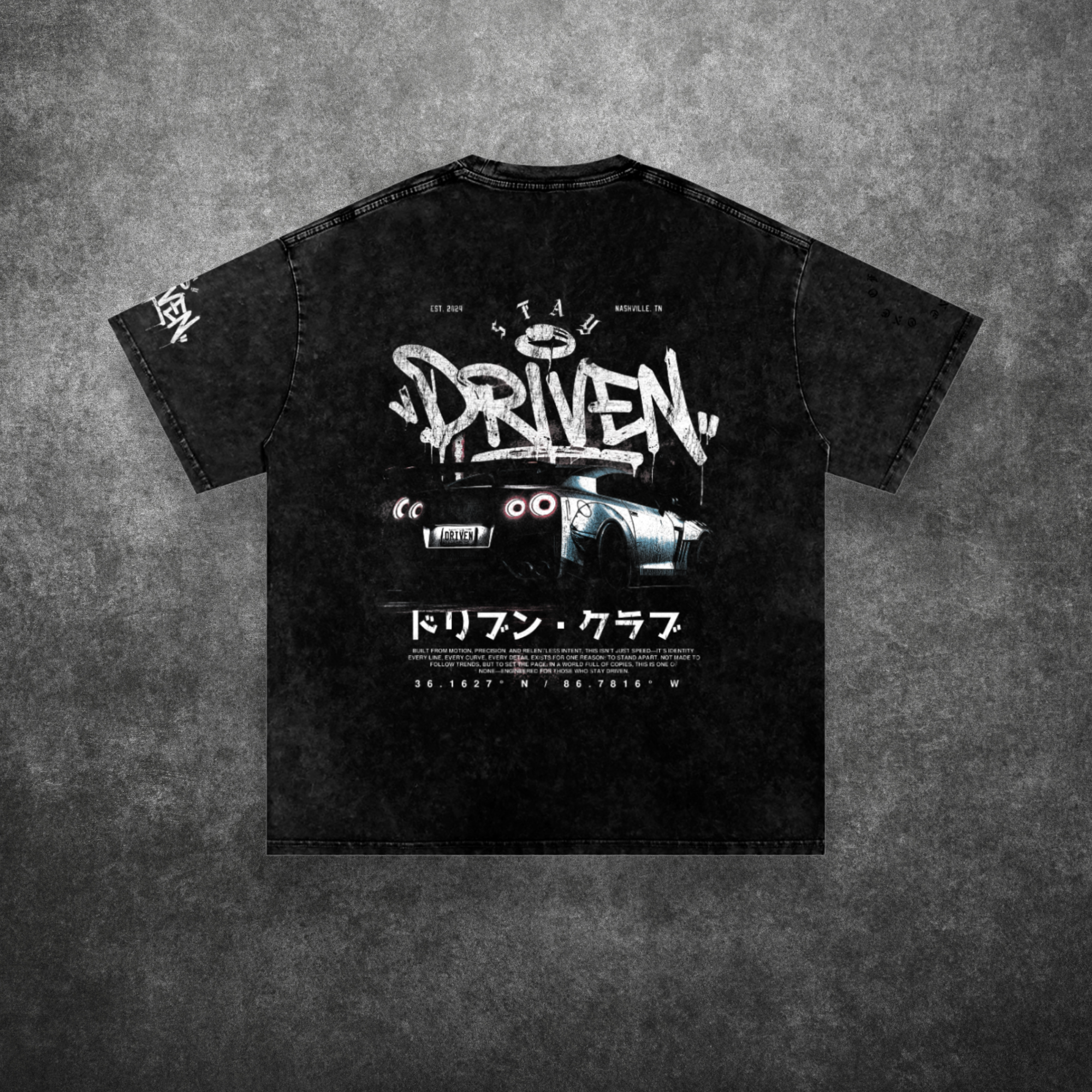 Black t-shirt with graphic design and text on a textured gray background